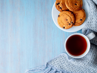 tea, teapot, copy space, warm knitted scarf on blue wooden background, cozy house, top view