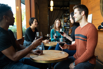 Group of friends drinking red wine at a cafe together
