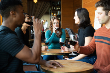 Group of friends drinking red wine at a cafe together