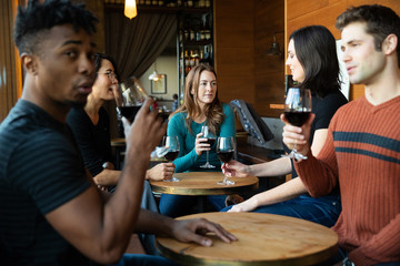 Group of friends drinking red wine at a cafe together
