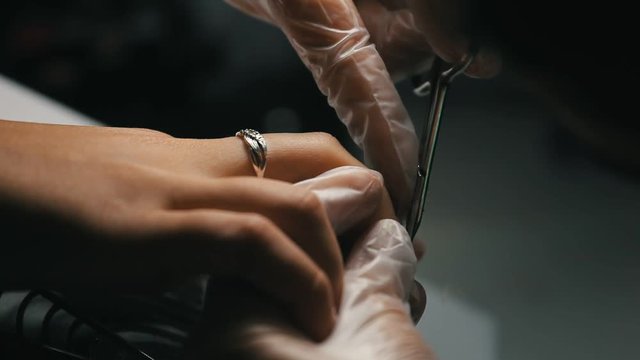 Master makes a manicure to young girl. Working with nails in a beauty salon.