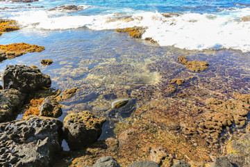 clear sea and rocks with small wave breaking