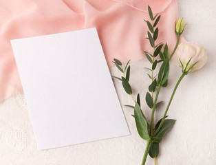 Wedding invitation mockup with blush silk and flowers