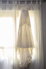 luxurious wedding dress hanging from a window