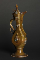 Fototapeta na wymiar ancient oriental metal teapot on dark background. antique bronze tableware