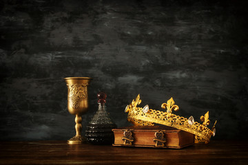 low key photo of beautiful queen/king crown and sword. fantasy medieval period.