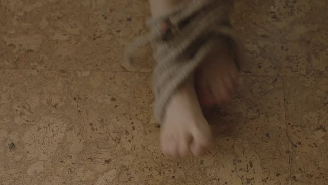 Feet of a Tied Up Woman Wriggling To Free Herself