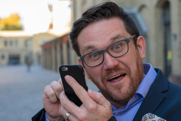 Crazy Business man surprised by message on mobile