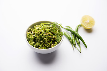 Hot and spicy green chilli chutney using hari mirch, cumin seeds, lemon juice and coriander. served in a bowl. selective focus