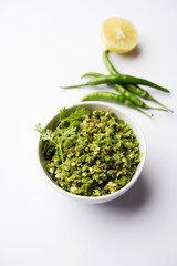 Hot and spicy green chilli chutney using hari mirch, cumin seeds, lemon juice and coriander. served in a bowl. selective focus