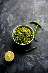 Hot and spicy green chilli chutney using hari mirch, cumin seeds, lemon juice and coriander. served in a bowl. selective focus