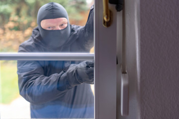 Einbrecher will mit einer Brechstange eine Haustür aufhebeln