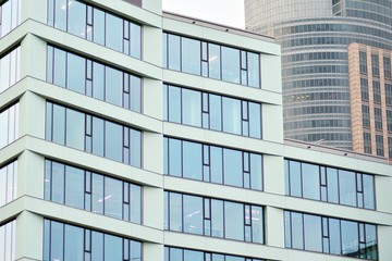 Facade fragment of a modern office building. Exterior of glass wall with abstract texture.
