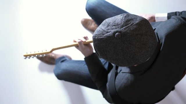 Man with a hat playing electric guitar in the studio