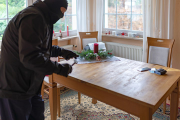 Einbrecher will Wertgegenstände vom Tisch stehlen