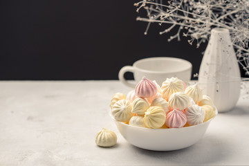 sweet marshmallow in the cup, delicious dessert, on a white background a vase with a branch