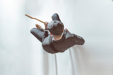 Man with a hat playing electric guitar in the studio