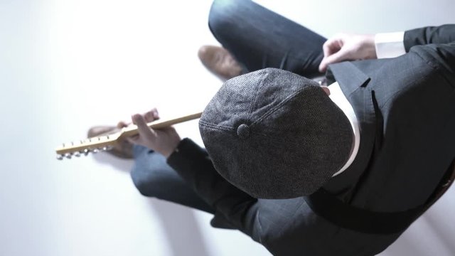 Man with a hat playing electric guitar in the studio