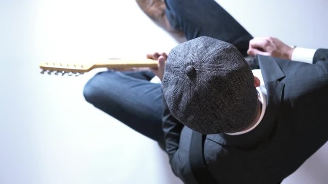 Man with a hat playing electric guitar in the studio