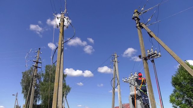 Remont power transformer. Maintenance of overhead power lines. Electrician lineman repairman worker at climbing work on electric post power pole and change transformer.