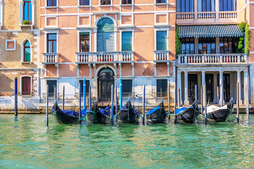 Fototapeta na wymiar Gondolas moored on the Grand Canal of Venice, summer view