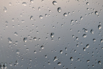 Rain drops on glass or windows show cloud reflection at winter