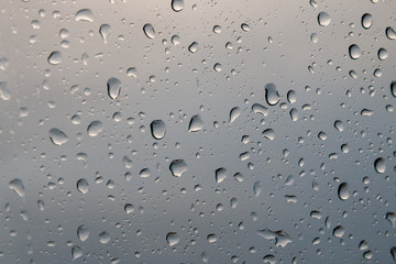 Rain drops on glass or windows show cloud reflection at winter