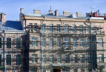 Fototapeta na wymiar Multi-storey building under repair, with scaffolding on the facade.