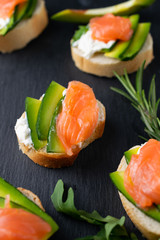 Snacks, bruschetta with cream cheese, avocado and salmon