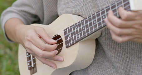 Woman enjoy play ukulele
