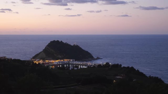 Harbour of Getaria at dusk with light house from Isla de San Anton and Bay of Biscay in the distance. Getaria, Spain.