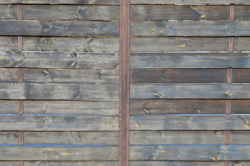 Texture of an old rustic wooden fence made of flat processed boards