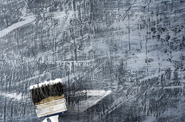 brush in black and white paint on the background of a concrete painted gray background at the bottom left