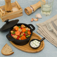 Roasted meat and vegetables in a cast iron pot.  Asian food – pork with vegetables 