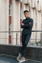 Portrait of a handsome young casual guy posing on street backgro