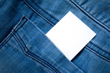 blank white paper or card in back pocket of blue jeans with copyspace for sale text or business concept