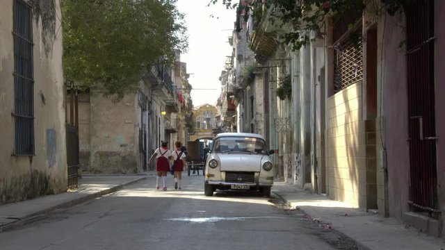 cuban school girls children walk in neighborhood alley street in old Havana, Cuba