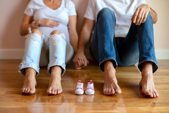 Future Mom And Dad Feet With Little Baby Shoes