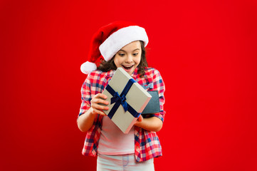 Happy winter holidays. Its for me. Small girl. Present for Xmas. Childhood. Christmas shopping. Little girl child in santa red hat. New year party. Santa claus kid. Christmas time