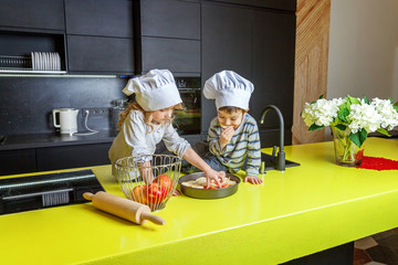 Little kids girl and boy with chef hat preparing bake homemade apple pie in kitchen. Brother and...