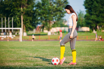 Obraz premium young woman kicking soccer ball