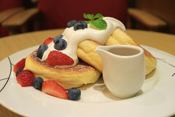 Fluffy Souffle Pancakes with Fresh Mix Berries and Mascarpone Cream Served on white Plate