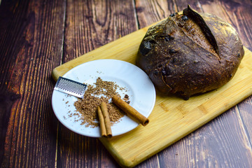 Chocolate bread, cinnamon  sticks on the wooden rustic table. Clean, bright, authentic, retro, contrast, horizontal. Copy space.