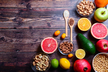 Concept Healthy food antioxidant products: avocado, nuts and, grapefruit, lime, lemon, apple, orange, pomegranate, rice, linseed on rustic wooden background. Copy space - Image