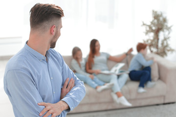 man standing in his living room and looking at his family