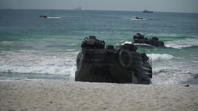 Slow motion shot of military amphibious vehicles getting out the sea