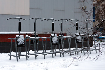 Plakat Outdoor exercise equipment is littered with snow. Snow does not remove the problem of snow removal.