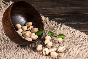 Roasted Pistachios nuts in plate on wooden table background