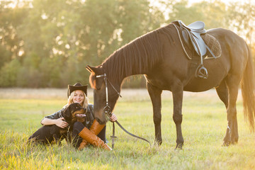 Girl equestrian rider sits near the horse. Horse farm. Horse theme