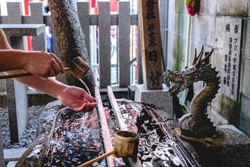 Naklejka premium Purify hands with water at shinto shrine, Shinsekai, Osaka, Japan